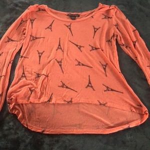 Peach colored shirt with black Eiffel Towers.